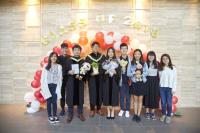 The graduating students took photos in front of the colourful balloon arch.